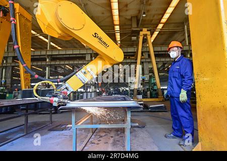 QINGZHOU, CHINE - 15 JUIN 2023 - Un robot effectue des opérations de coupe dans l'atelier de production d'une entreprise de fabrication d'équipements à Qingzhou Banque D'Images