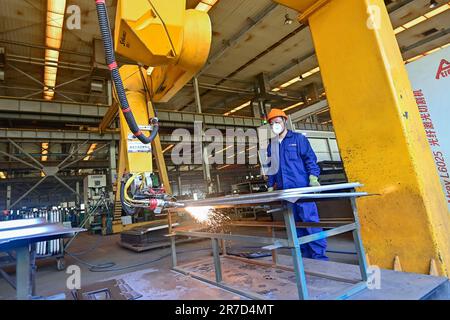 QINGZHOU, CHINE - 15 JUIN 2023 - Un robot effectue des opérations de coupe dans l'atelier de production d'une entreprise de fabrication d'équipements à Qingzhou Banque D'Images