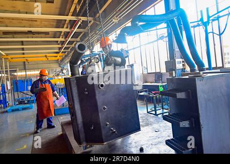 QINGZHOU, CHINE - le 15 JUIN 2023 - Un travailleur soulève des marchandises dans un atelier de production d'une entreprise de fabrication d'équipement à Qingzhou, dans le Sha de Chine orientale Banque D'Images