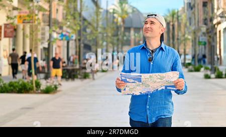 Homme explorant la ville avec une carte dans ses mains à Alicante, Espagne Banque D'Images