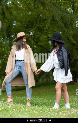 Deux jeunes amies profitent d'une promenade en plein air dans un parc luxuriant et dynamique Banque D'Images