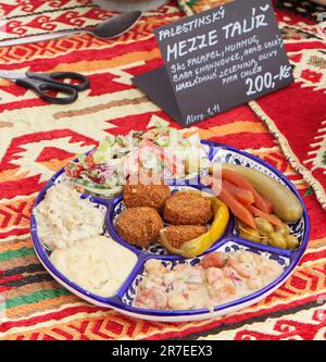 Plat de Mezze Palestinien, une sélection de nourriture du Moyen-Orient, le falafel, le houmous, la ghanouse de baba, la salade arabe, cornichons, olives et pain pita. Banque D'Images