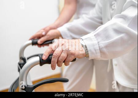 L'infirmière aide son patient senior sur le secoueur rabattable. Récupération pour les personnes âgées, soins aux aînés, maison de soins infirmiers. Photo de haute qualité Banque D'Images