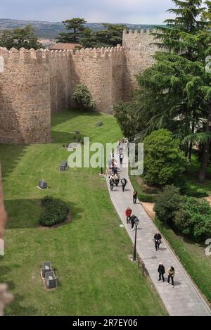 Mur de la ville d'Avila, vue des gens marchant le long d'une section des murs de la ville médiévale bien préservés qui entourent Avila dans le centre de l'Espagne. Banque D'Images