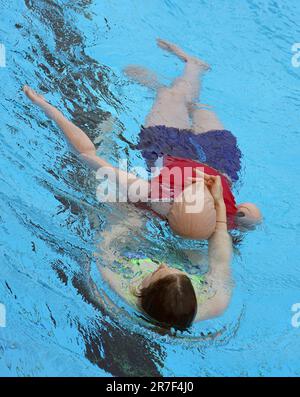 14 juin 2023, Berlin: Une jeune femme démontre la procédure de sauvetage d'une victime sur un mannequin pendant la pré-nage des sauveteurs potentiels à la piscine d'été Humboldthain. Les piscines extérieures de Berlin sont toujours à la recherche de sauveteurs pour la saison estivale en cours. Ils doivent soutenir le personnel déjà existant. Les parties intéressées ont pu présenter leurs compétences avant la nage. À cette fin, ils ont dû effectuer un exercice de sauvetage combiné, au cours duquel un mannequin de sauvetage a été récupéré de l'eau et une réanimation a été démontrée. (À dpa: 'Bäder-Betriebe: Bonne participation à l'agent de sauvetage pré- Banque D'Images