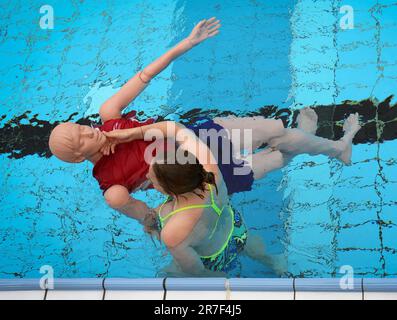 14 juin 2023, Berlin: Une jeune femme démontre la procédure de sauvetage d'une victime sur un mannequin pendant la pré-nage des sauveteurs potentiels à la piscine d'été Humboldthain. Les piscines extérieures de Berlin sont toujours à la recherche de sauveteurs pour la saison estivale en cours. Ils doivent soutenir le personnel déjà existant. Les parties intéressées ont pu présenter leurs compétences avant la nage. À cette fin, ils ont dû effectuer un exercice de sauvetage combiné, au cours duquel un mannequin de sauvetage a été récupéré de l'eau et une réanimation a été démontrée. (À dpa: 'Bäder-Betriebe: Bonne participation à l'agent de sauvetage pré- Banque D'Images