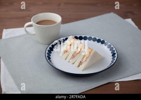 sandwich avec café aux œufs de jambon latte isolé sur la table Banque D'Images