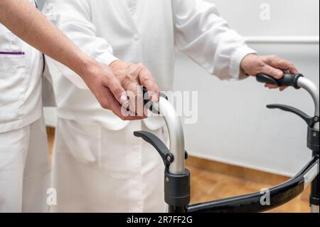 L'infirmière aide son patient senior sur le secoueur rabattable. Récupération pour les personnes âgées, soins aux aînés, maison de soins infirmiers. Photo de haute qualité Banque D'Images