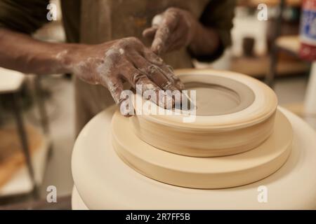 Céramiste africain travaillant sur le tournage de l'argile dans un moule sur une roue de poterie Banque D'Images