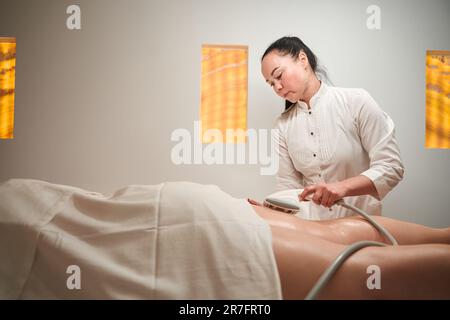 La masseuse fait du client un matériel de massage des pieds anti-cellulite Banque D'Images