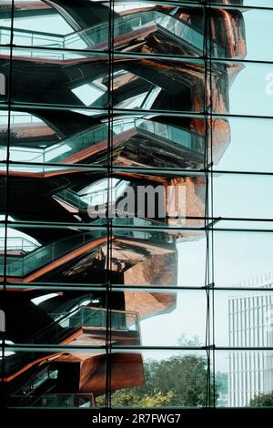 New York, États-Unis - 19 mai 2023 : la structure du navire se reflète sur la surface extérieure en verre des boutiques et des restaurants du centre commercial de Hudson yards Banque D'Images