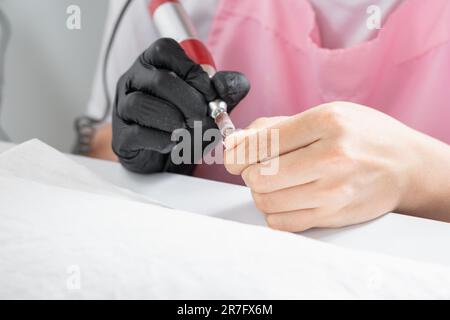 gros plan des mains d'une femme latina en utilisant un polisseur électrique pour polir ses ongles Banque D'Images