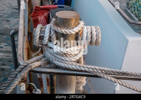Photographie d'une corde blanche enroulée autour d'un bateau en acier amarant un bollard sur King Island, dans le détroit de Bass en Tasmanie, en Australie Banque D'Images