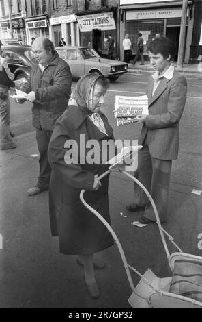 Les partisans du Front national vendent les nouvelles du Front national, chaque dimanche matin à la jonction de Brick Lane et Bethnal Green Road. Londres. Il y a eu une attente régulière, avec la police et les membres du Parti socialiste ouvrier vendant leur journal hebdomadaire. Whitechapel, est de Londres, Angleterre vers 1976. 1970S ROYAUME-UNI HOMER SYKES Banque D'Images