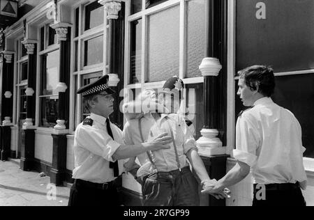 La police arrête un jeune skinhead, un partisan du Front national lors d'une confrontation régulière dimanche entre le Parti socialiste des travailleurs et le Front national à l'extrémité nord de Brick Lane, Whitechapel, East London, Angleterre 1978. ANNÉES 1970 ROYAUME-UNI HOMER SYKES Banque D'Images