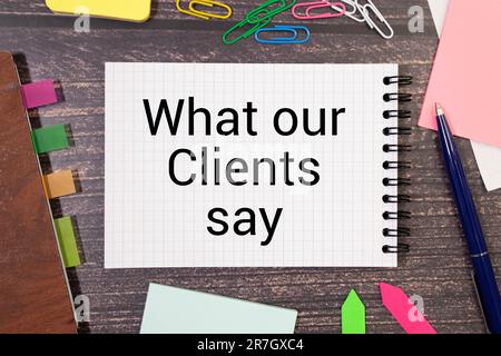 Vue de dessus de la plante, loupe, horloge et main tenant stylo écriture ' ce que nos clients disent ' Banque D'Images