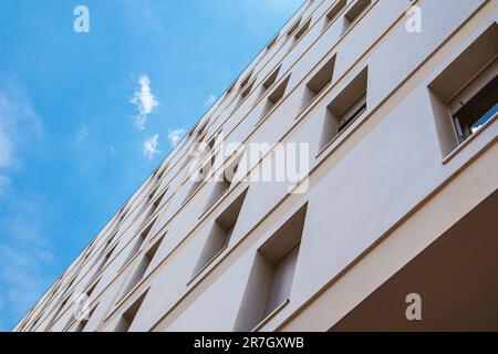 Façade beige d'un immeuble résidentiel moderne de plusieurs étages, vue de bas en haut sur le ciel bleu. Détails de la maison, architecture extérieure basse angl Banque D'Images