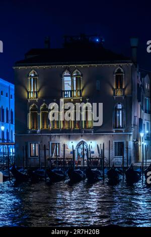 Gondoles amarrées par un palais vénitien sur le Grand Canal la nuit Banque D'Images