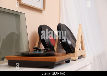 Disques en vinyle et lecteur sur table en bois blanc à l'intérieur Banque D'Images