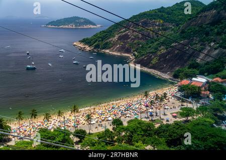 Vue sur la plage bondée de Praia Vermelha avec vue partielle sur la place du général Tiburcio ci-dessous dans le quartier d'Urca sous un ciel bleu ensoleillé l'après-midi d'été. Banque D'Images