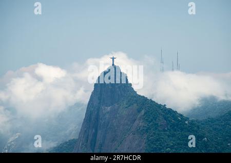 Vue lointaine de la montagne du Corcovado (hunchback), maison de la statue du Christ Rédempteur telle que vue de la montagne de Sugarloaf sous ciel bleu ciel nuageux d'été. Banque D'Images