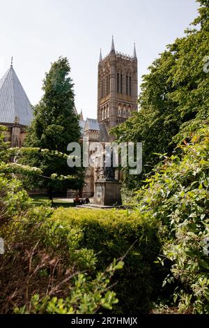 La statue d'Alfred Lord Tennyson assise sur Lincoln Cathedral Green une statue classée de catégorie II, datant de 1905, par G F Watts, RA et restaurée en 1970. C'est une figure debout en bronze avec un chien, sur un pied d'ashlar avec des plaques à l'est et à l'ouest. Banque D'Images