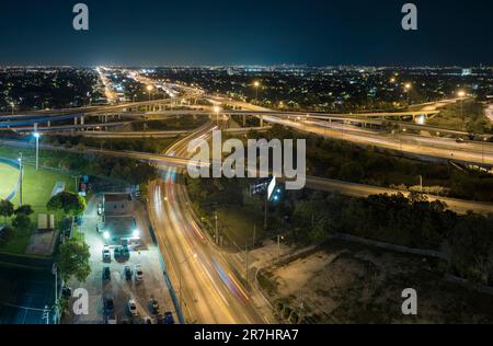 Vue depuis le dessus de l'intersection de la grande autoroute américaine à Miami, Floride la nuit avec des voitures et des camions rapides. USA infrastructure de transport co Banque D'Images