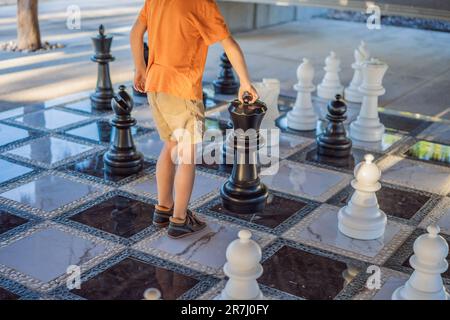 Père et fils jouant aux échecs et passant du temps ensemble à l'extérieur. Jeu d'échecs pour enfants Banque D'Images