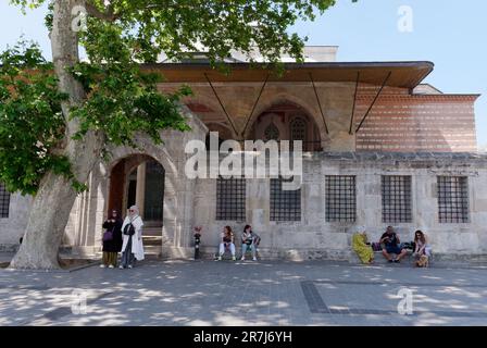 Personnes assises à l'ombre à l'entrée de Hatice Turhan valide Sultan Türbesi (Tombeau de Turhan Sultan) à Istanbul, Turquie Banque D'Images