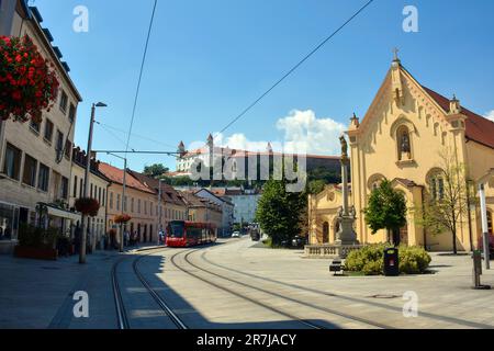 Rues colorées de la vieille ville de Bratislava, avec la rue L'église Stephan Capuchin, le tramway et le château en arrière-plan Banque D'Images