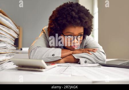 Employé fatigué, ennuyé et frustré assis au bureau avec la charge de travail de la paperasserie Banque D'Images