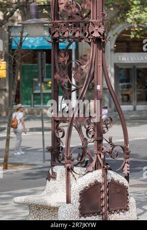 Banc public avec ornement en fer forgé dans la rue Passeig de Gracia à Barcelone, Espagne. Banque D'Images