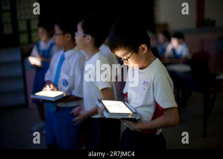 Les écoliers de Singapour utilisent la technologie d'immersion 4D dans un laboratoire informatique pendant un cours d'enrichissement de vacances d'été. Banque D'Images