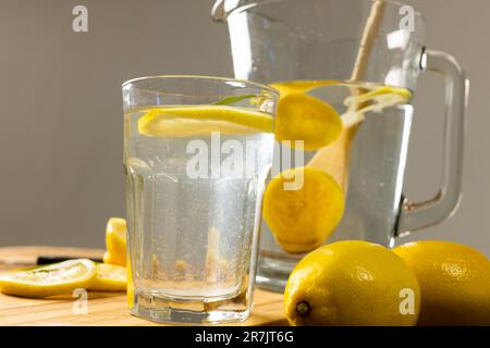 Gros plan du pichet et du verre à boire avec de la limonade sur fond gris, espace de copie Banque D'Images