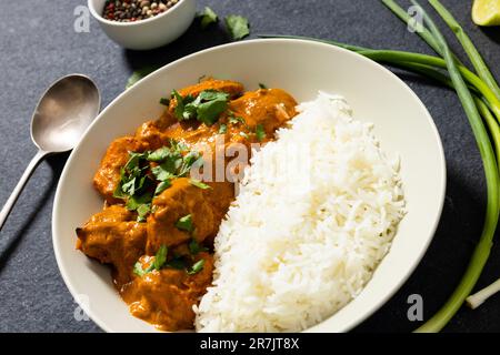 Vue à angle élevé du riz avec sauce à la viande servi dans un bol avec des herbes et une cuillère sur la table Banque D'Images