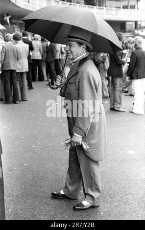Match de cricket annuel Eton v Harrow. Un vieux Etonien marche à travers un groupe de savants vêtus de façon décontractée. Il porte un surmatelas gris et un manteau croisé style Régence croisé assorti, avec une chemise et un cravat à col d'aile. Des gants gris Buckskin et des chaussures noir et blanc à deux tons complètent son ensemble. Sûrement, la hauteur de l'élégance sartorial ? St Johns Wood, Londres, Angleterre vers juin 1975. 1970S ROYAUME-UNI HOMER SYKES Banque D'Images