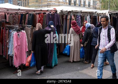 Les musulmanes parcourent une cabine vendant des foulards au marché de Whitechapel sur Whitechapel High Street le 25th mai 2023 à Londres, au Royaume-Uni. Whitechapel est un quartier ethniquement diversifié et dynamique du quartier de l'est, qui abrite une population importante de résidents du Bangladesh. Cela peut être vu le long des trottoirs où le marché de Whitechapel et les magasins environnants interagissent avec cette société vraiment multiculturelle. Banque D'Images