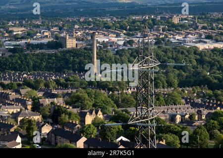 Les pylônes d'électricité ont vue sur les maisons situées juste à l'extérieur du centre-ville le 8th juin 2023 à Halifax, au Royaume-Uni. Halifax est une ville du quartier de Calborough dans le West Yorkshire et a été une ville de moulin prospère pendant la révolution industrielle. Ces lignes électriques aériennes permettent la transmission et la distribution d'énergie électrique sur de grandes distances alimentant les foyers et les entreprises à travers le Royaume-Uni. Banque D'Images