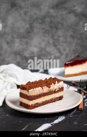 Tiramisu et cheesecake sur fond sombre. délicieux gâteaux Banque D'Images