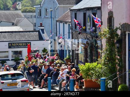Une scène animée avec des gens assis à l'extérieur de deux des pubs les plus populaires de Saundersfoot - le HARBWR Bar & Kitchen, et le Royal Oak Inn. Banque D'Images
