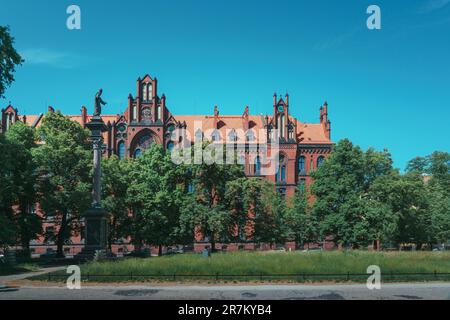 Bâtiment du séminaire catholique néo-gothique à Wroclaw. Sculpture de Jésus Christ dans une tiara sur une colonne en face de l'édifice Banque D'Images