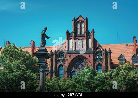 Bâtiment du séminaire catholique néo-gothique à Wroclaw. Sculpture de Jésus Christ dans une tiara sur une colonne en face de l'édifice Banque D'Images