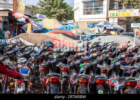 A la périphérie d'un marché, motos dans les rangées étroites sur l'aire de stationnement. Bamako, Mali. Banque D'Images