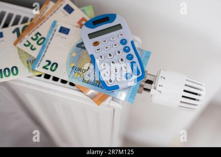 Nouveau thermostat avec euro cash sur un radiateur de chauffage à la maison. Un chauffage coûteux coûte une image symbolique. Banque D'Images