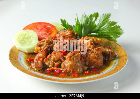 Cuisine indonésienne culinaire sur antique plate.chicken rica-rica avec tomate, concombre, poulet épicé céleri.Sweet avec piment rouge sur fond blanc Banque D'Images