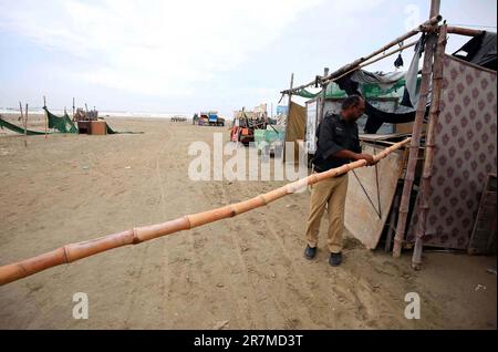 Les officiers de police sont en état d'alerte le long d'une plage fermée avec vue sur la mer, au milieu du cyclone Biporjoy, à Karachi vendredi, 16 juin 2023. Banque D'Images