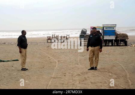 Les officiers de police sont en état d'alerte le long d'une plage fermée avec vue sur la mer, au milieu du cyclone Biporjoy, à Karachi vendredi, 16 juin 2023. Banque D'Images