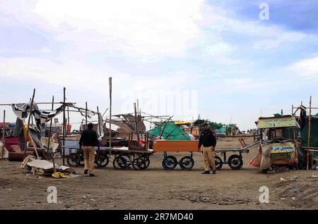 Les officiers de police sont en état d'alerte le long d'une plage fermée avec vue sur la mer, au milieu du cyclone Biporjoy, à Karachi vendredi, 16 juin 2023. Banque D'Images