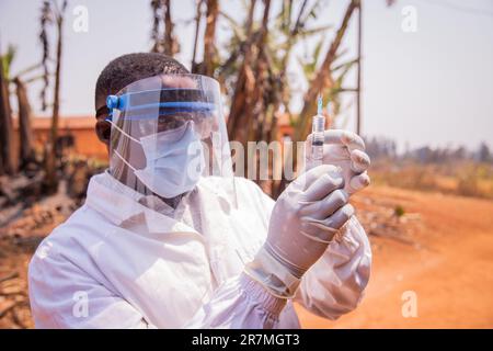 Un médecin en Afrique vérifie la seringue de vaccin Banque D'Images