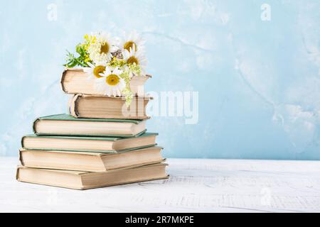 Livre avec des pages ouvertes en forme de coeur et des livres empilés sur le bureau de lecture dans la bibliothèque. Bibliothèque nationale, amateurs de livres jour ou mois. Retour à l'école ou Banque D'Images